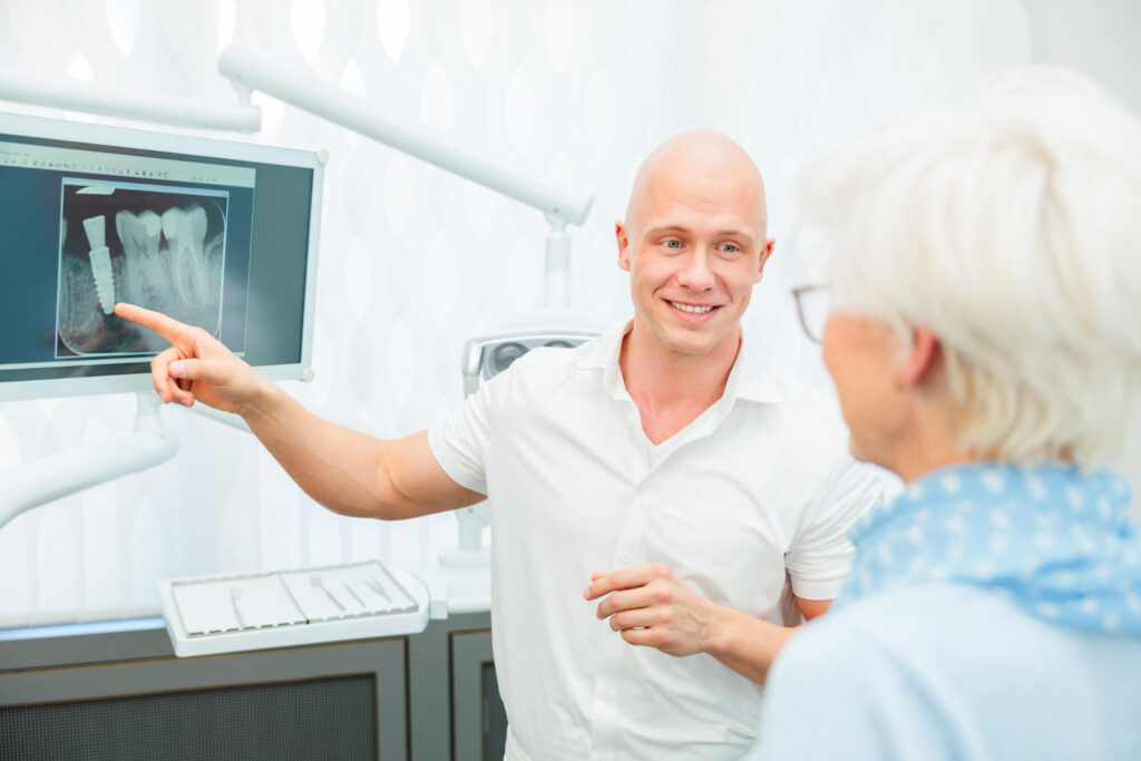 Zahnarzt Dr. Nowak informiert eine Patientin in Berlin über die präzise Implantatplanung mit navigierter Technik.