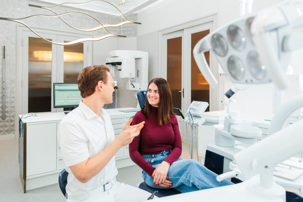 Zahnarzt Dr. Nowak berät eine Patientin, wann ein abgebrochener Zahn untersucht werden sollte und welche Behandlungen infrage kommt!